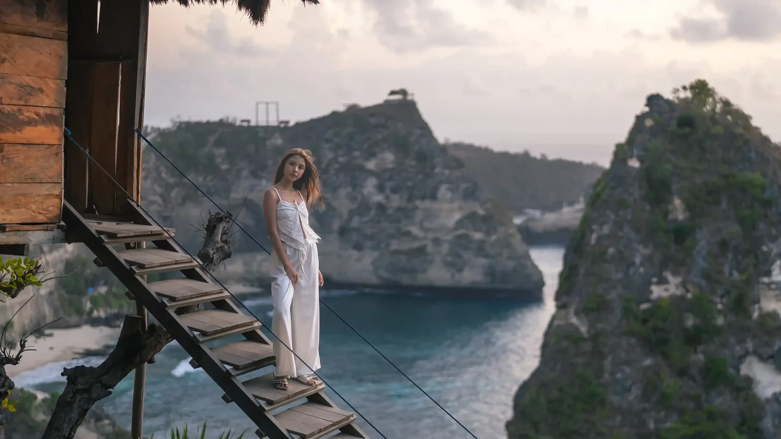 A visitor on the wooden stairway above the cliffs of Nusa Penida