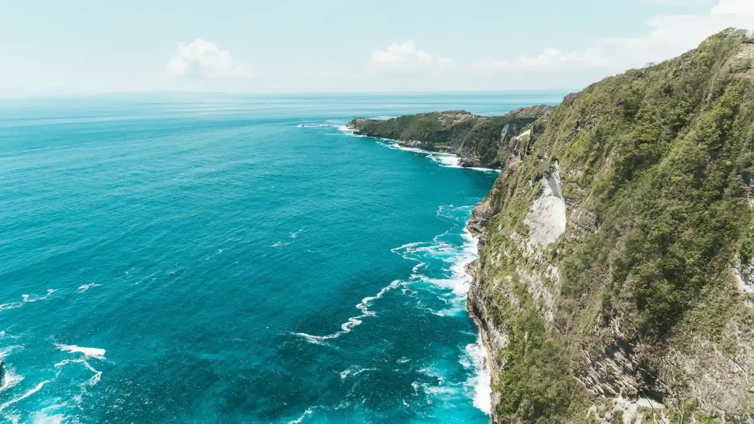 Limestone cliffs above turquoise water on the Nusa Penida coast